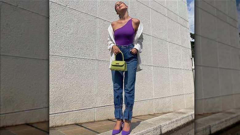 Woman in jeans with green purse