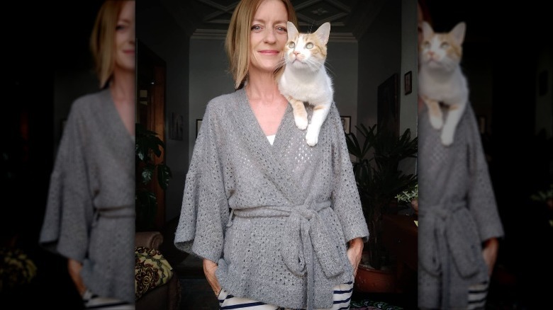 woman with cat in a robe sweater