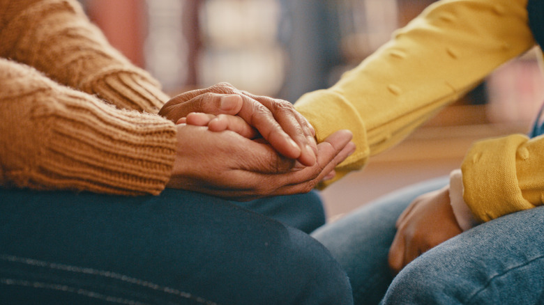 Woman comforting friend, close-up of hands