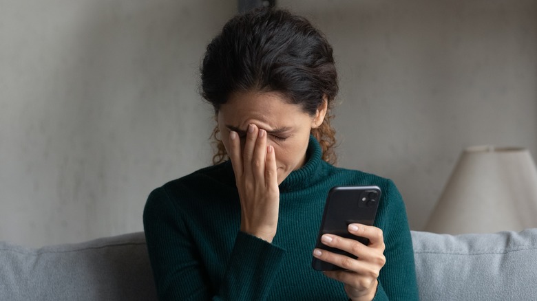 Stressed woman looking at her phone 