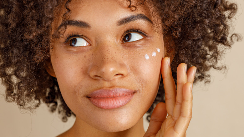 Woman applying moisturizer