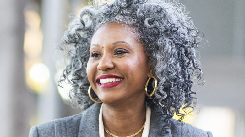 Smiling woman with curly silver hair