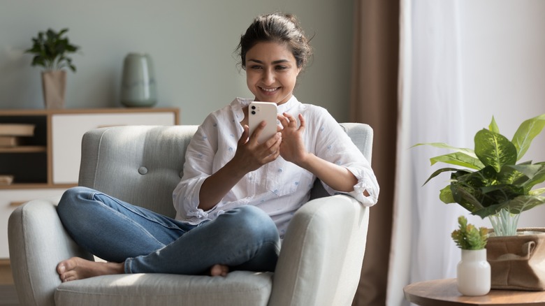 Woman smiles while reading cell phone