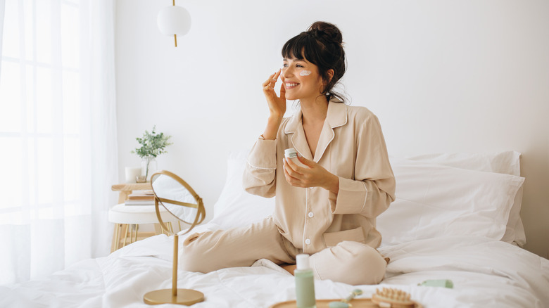 Woman applying moisturizer