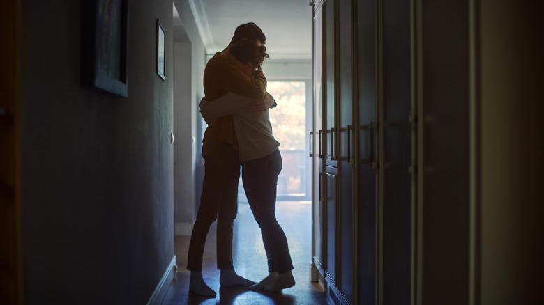 Couple hugging in hallway