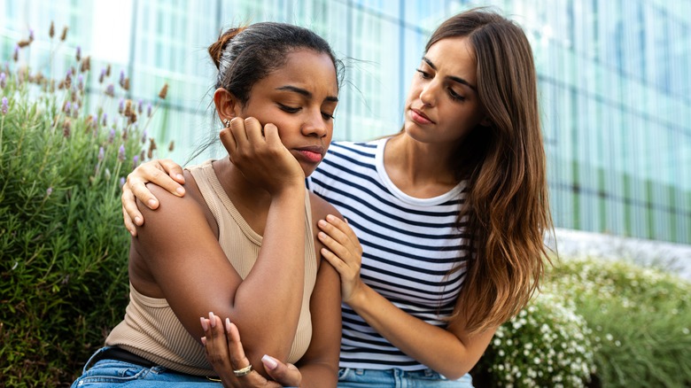 Woman apologizing and comforting friend