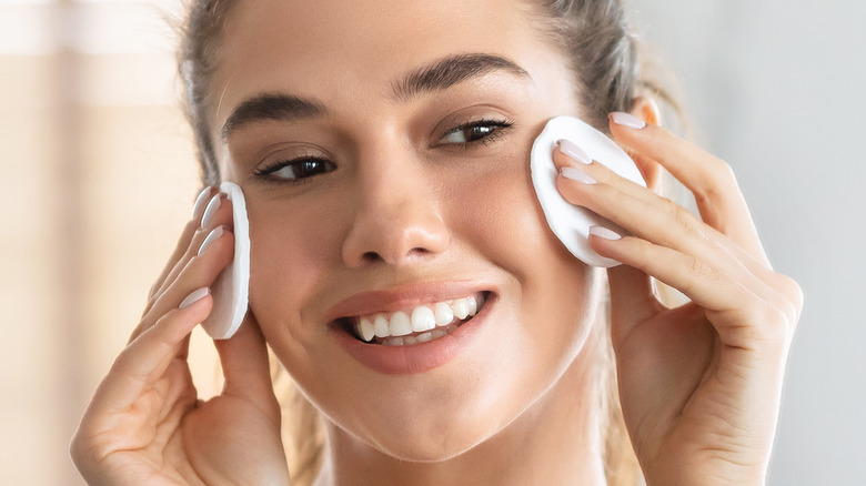 woman apply toner to face