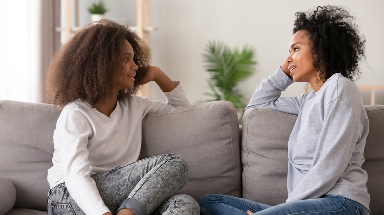 Mother and daughter have discussion on sofa