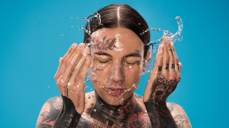 person washing their tattooed face