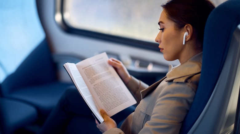 Woman reading book on train