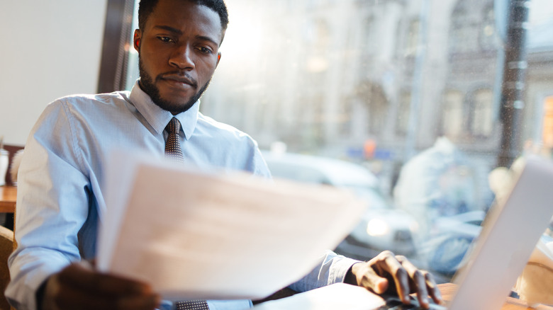 Professional man reading paperwork in cafe