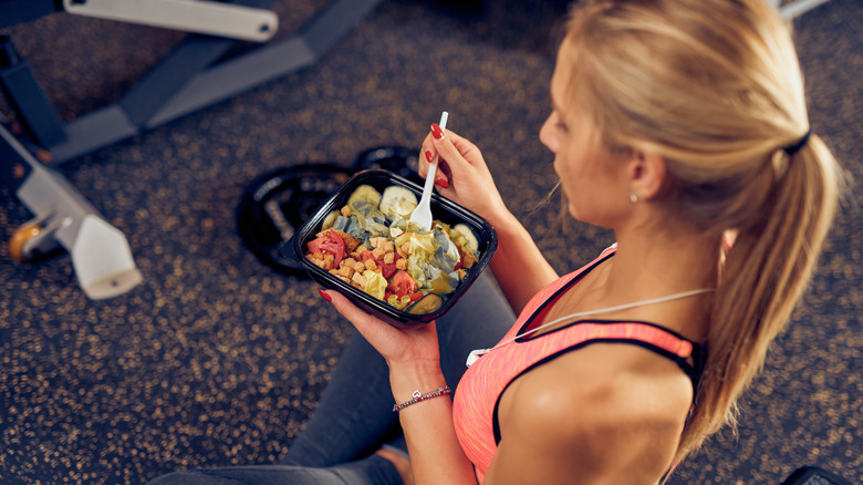 woman in sportswear eating salad