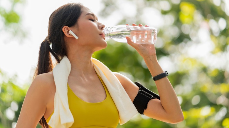 woman in workout gear drinking water