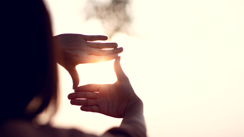 Woman framing sightline with hands