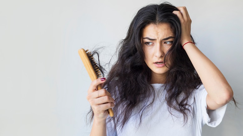 Woman with hair loss on hair brush