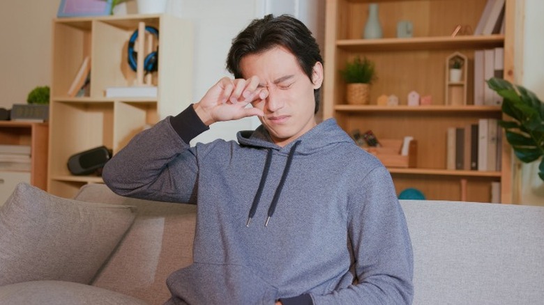 Young man rubbing his eye