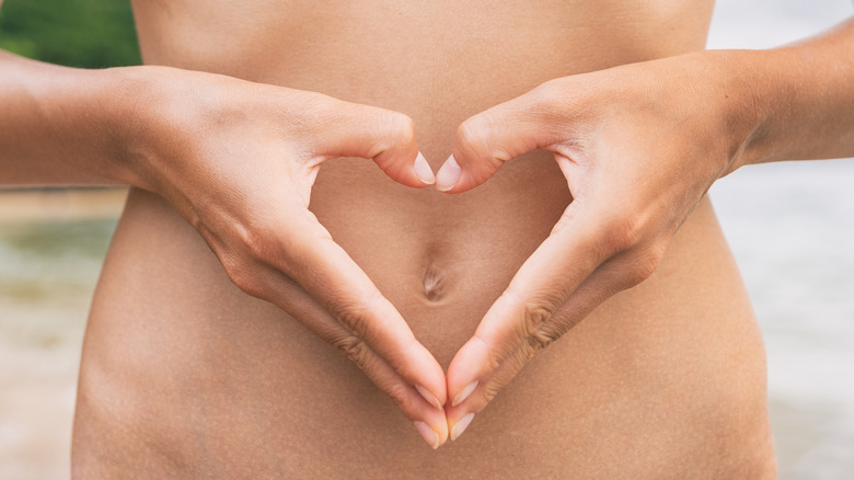 hands held as heart over stomach