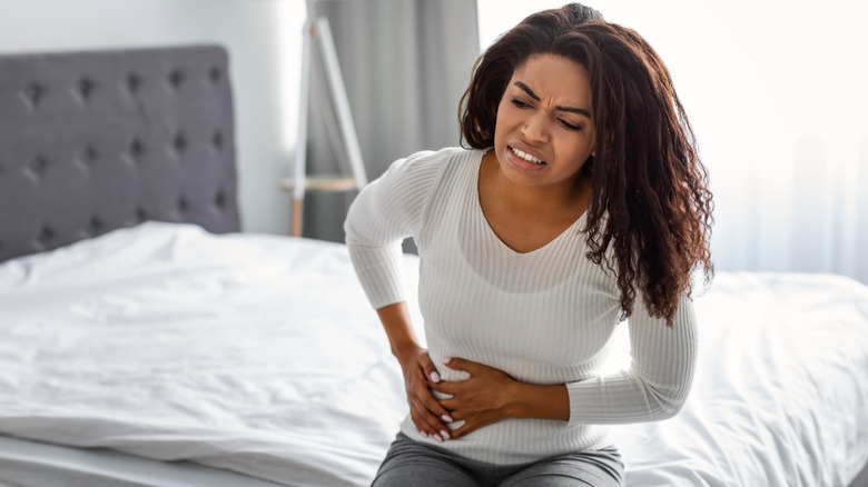 woman holding her stomach in pain