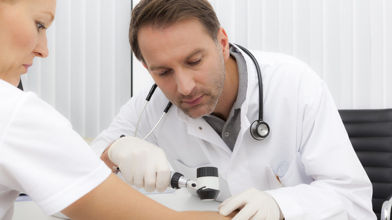 Doctor examines a patient's skin