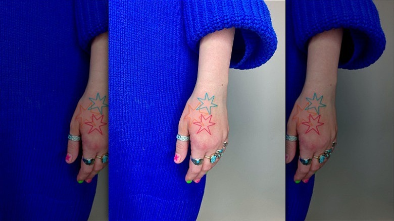 woman with colorful starburst hand tattoos