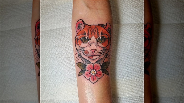 arm with americana cat tattoo
