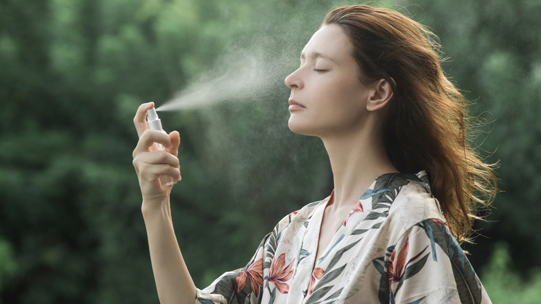 Woman spritzing her face