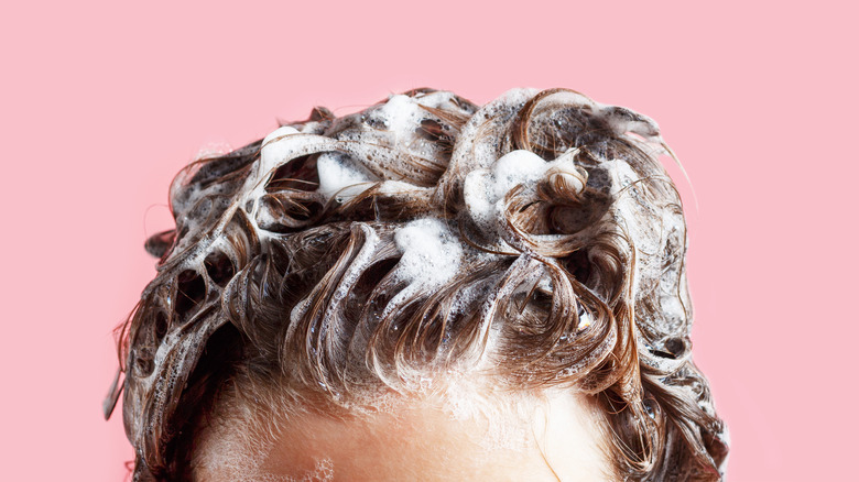 Woman with shampoo suds in hair