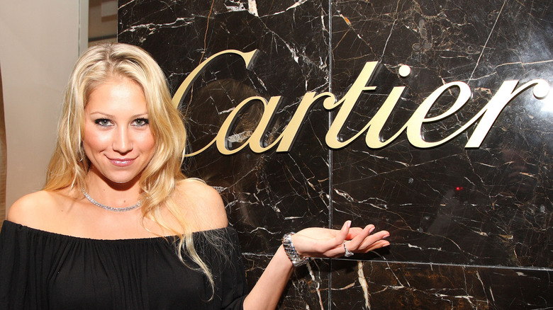 Anna Kournikova posing beside a Cartier sign.