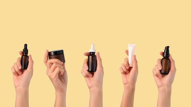 Various hands holding different skincare products