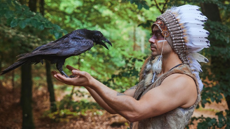 Native American man holding crow