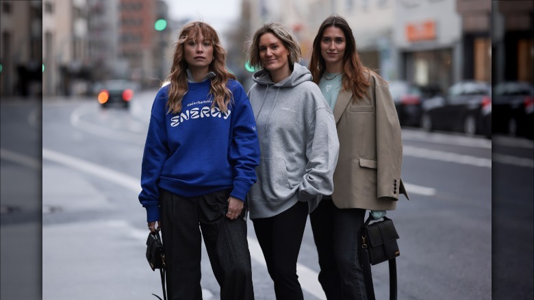 Three women pose in simple neutral styles