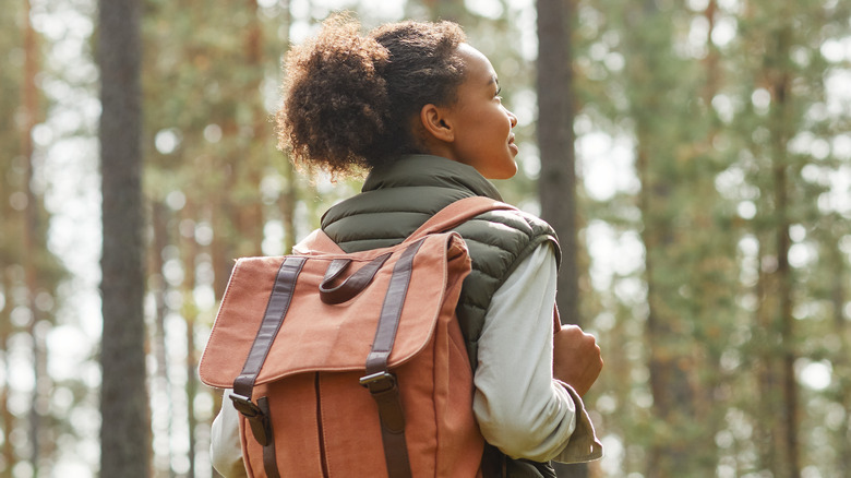 Smiling woman hiking in forest