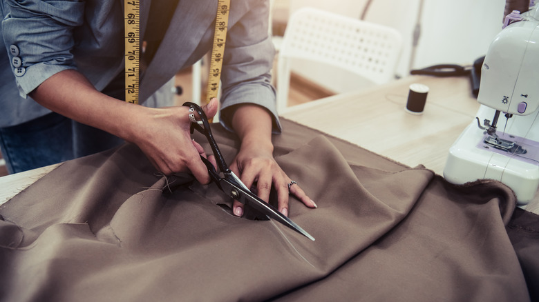 Woman cutting fabric with scissors 