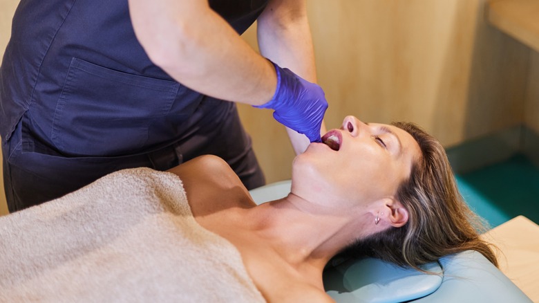 Therapist performing intraoral massage