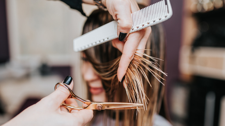 woman getting layers at hair salon