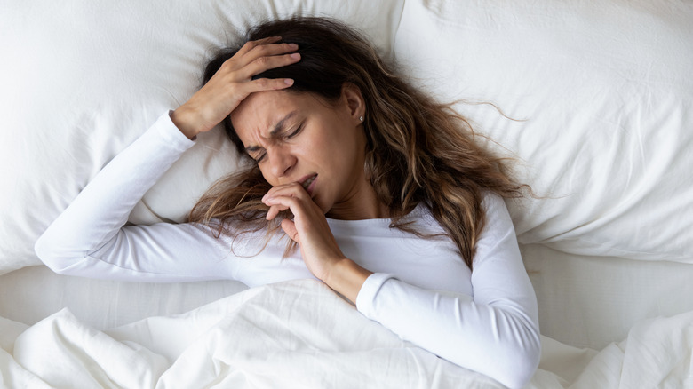 woman feeling unwell in bed