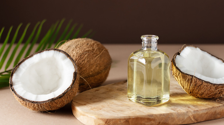 Raw coconuts beside coconut oil 