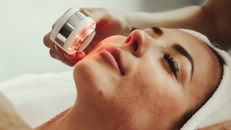 Woman receiving light therapy facial