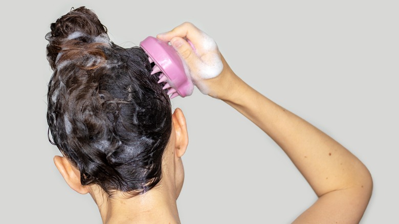 Woman shampoos hair 