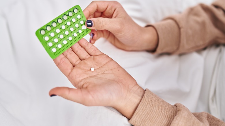 Woman holding birth control pills