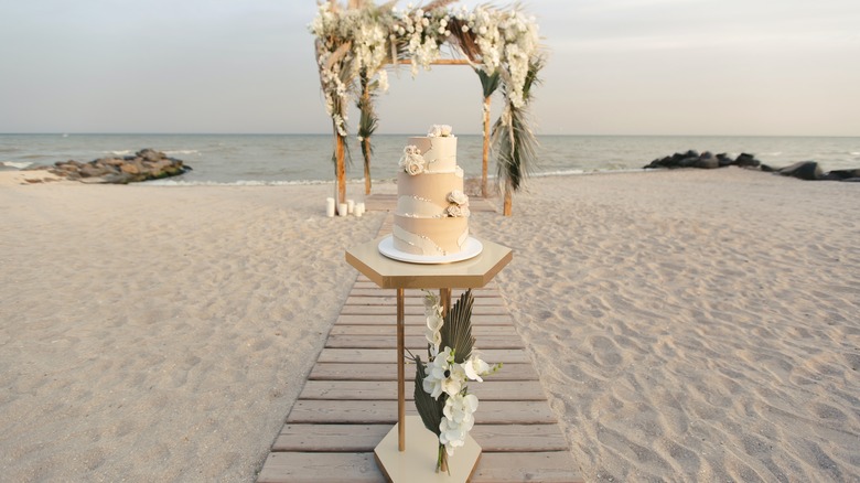 Wedding cake and arch on beach