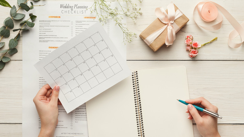 Woman's hands and wedding planning materials