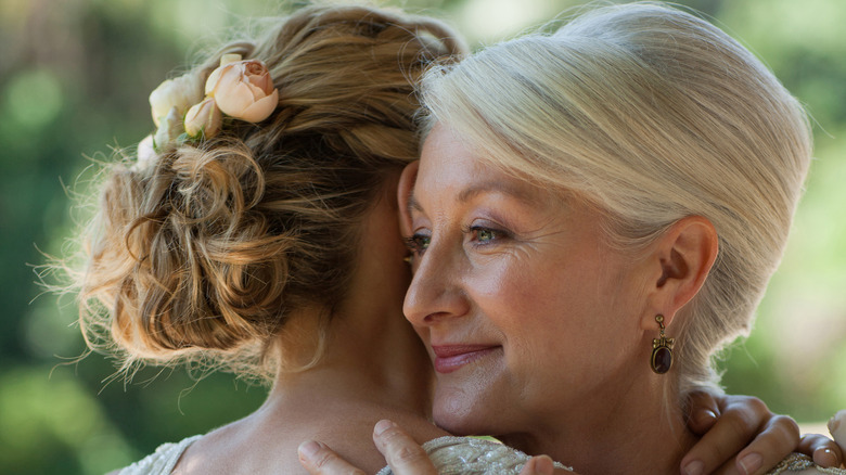 Bride embracing smiling mother