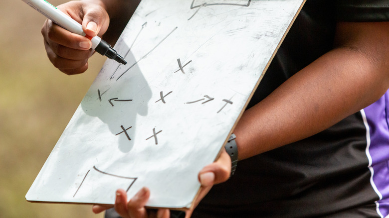 Woman drawing plans on clipboard