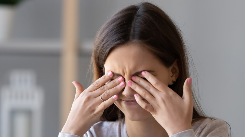 woman rubbing eyes