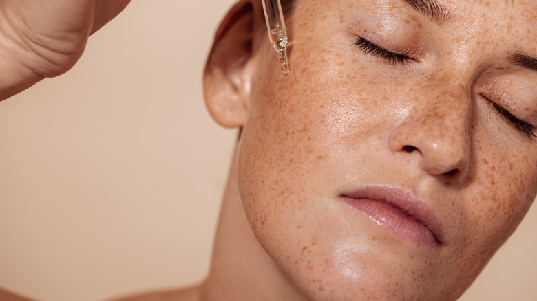 Woman applying face serum 