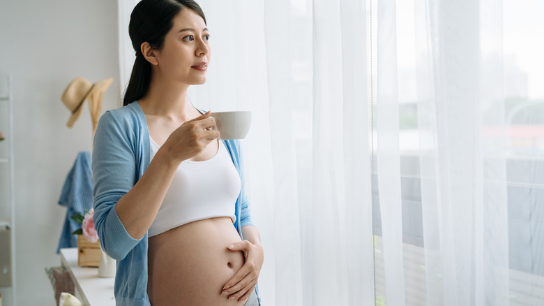 Pregnant woman drinking cup of tea
