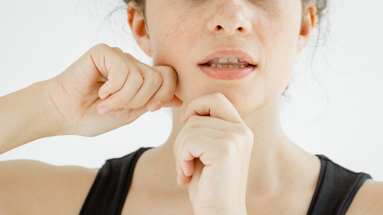 woman performing facial massage on her self