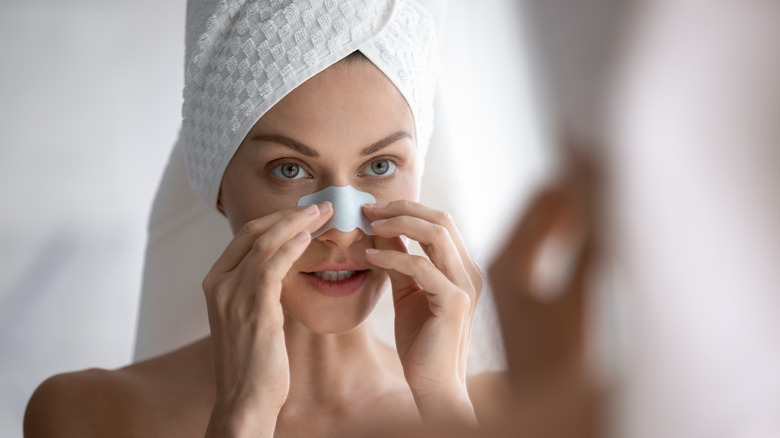 woman wearing a nose strip and towel on her head