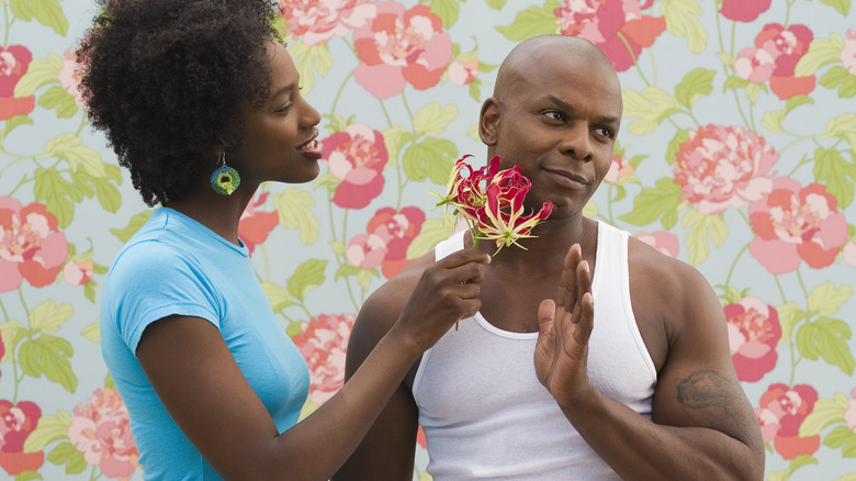 Man pushing away flower